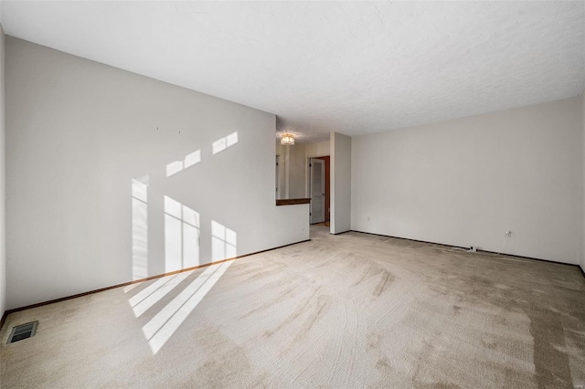 unfurnished room featuring light carpet and a textured ceiling