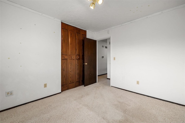 unfurnished bedroom with light colored carpet and a textured ceiling