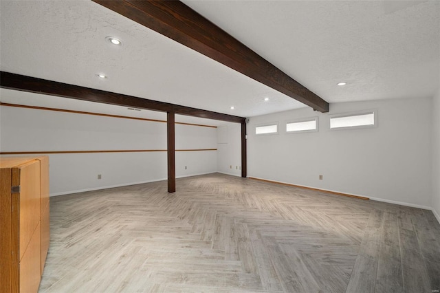 basement featuring light parquet flooring and a textured ceiling