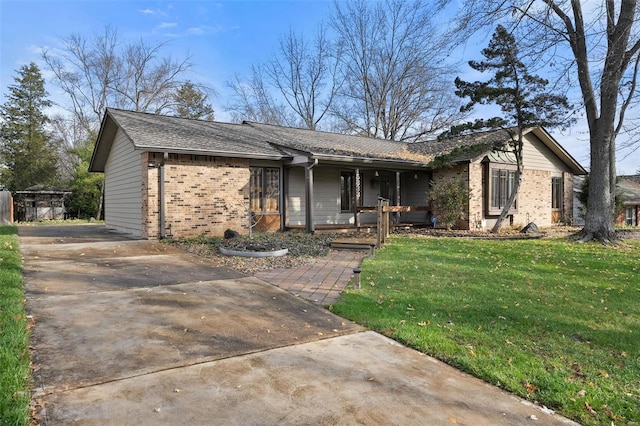 ranch-style house featuring covered porch and a front lawn