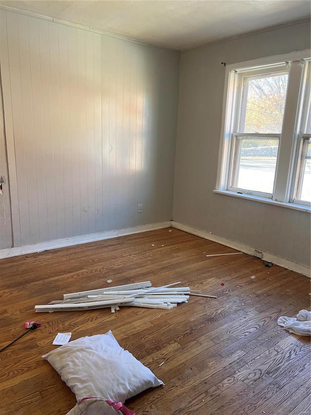 empty room with wood walls and wood-type flooring