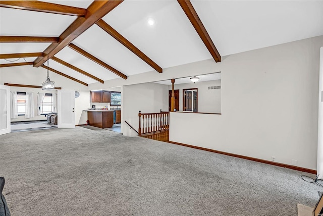 unfurnished living room featuring carpet and lofted ceiling with beams