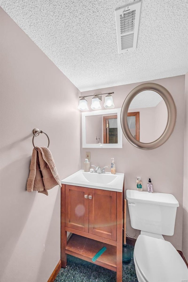 bathroom featuring vanity, a textured ceiling, and toilet