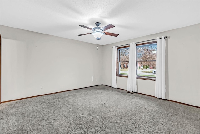 empty room with carpet, ceiling fan, and a textured ceiling