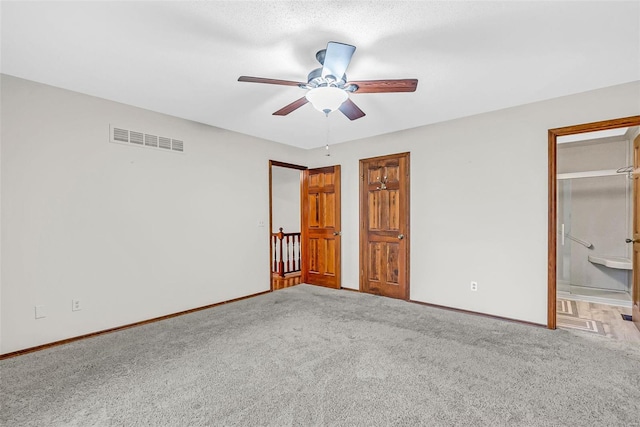 unfurnished bedroom with carpet, connected bathroom, and ceiling fan