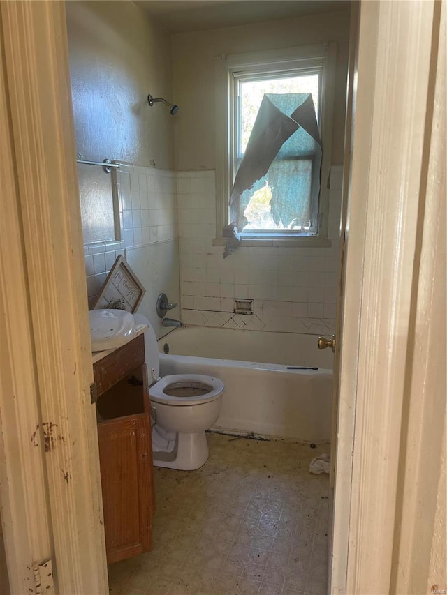 bathroom with vanity, toilet, and tile walls