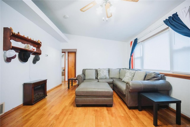 living room with ceiling fan, light hardwood / wood-style floors, and lofted ceiling