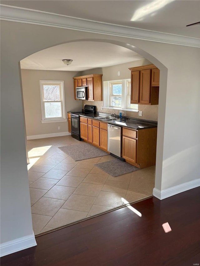 kitchen with a wealth of natural light, appliances with stainless steel finishes, and light hardwood / wood-style flooring