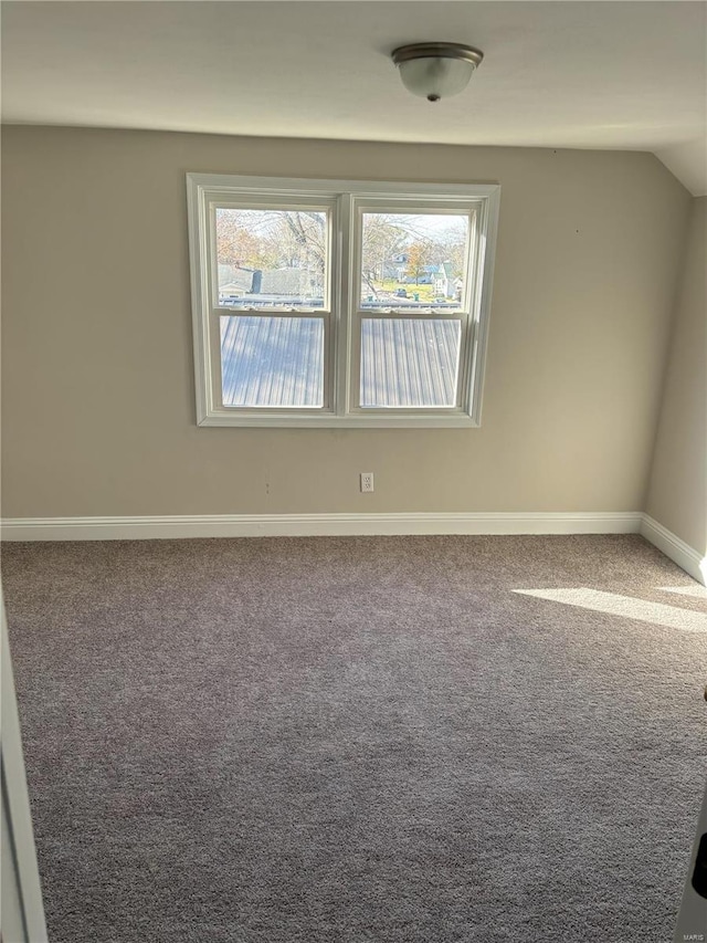 empty room featuring carpet floors and vaulted ceiling