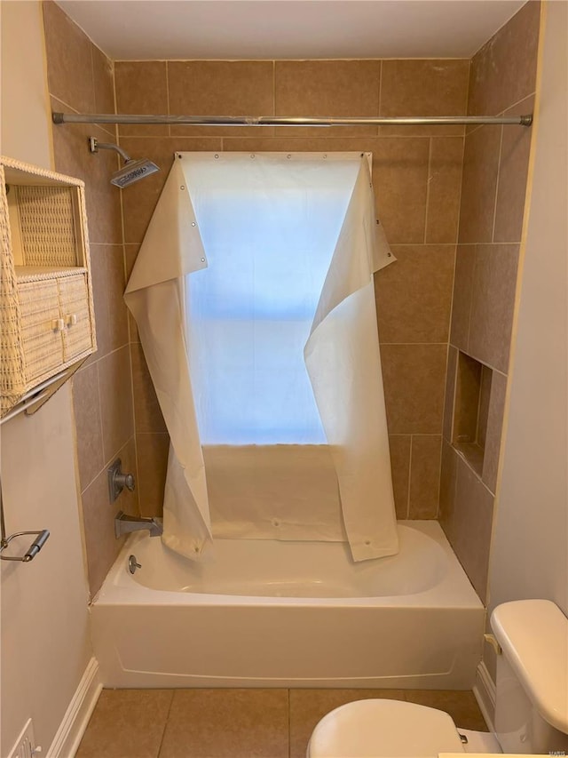 bathroom featuring tile patterned floors, toilet, and tiled shower / bath