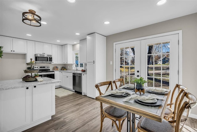 kitchen with white cabinetry, french doors, and appliances with stainless steel finishes