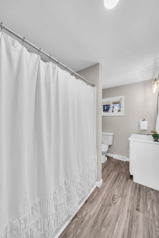 bathroom featuring hardwood / wood-style floors and toilet