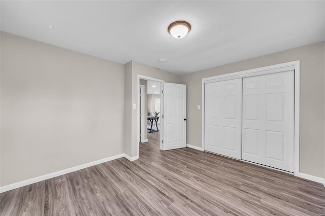 unfurnished bedroom featuring a closet and light hardwood / wood-style flooring