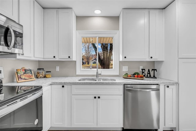 kitchen featuring light stone counters, sink, white cabinetry, and stainless steel appliances