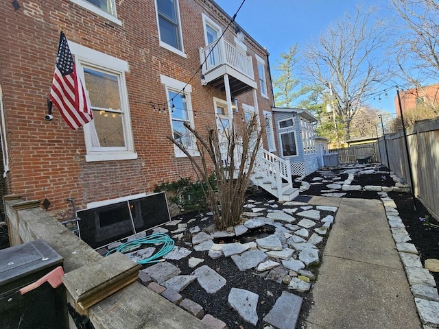 exterior space featuring brick siding, fence, and a patio