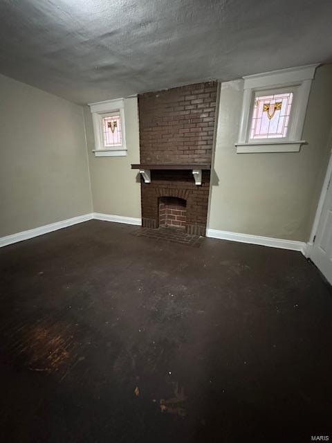 unfurnished living room featuring a textured ceiling and a brick fireplace