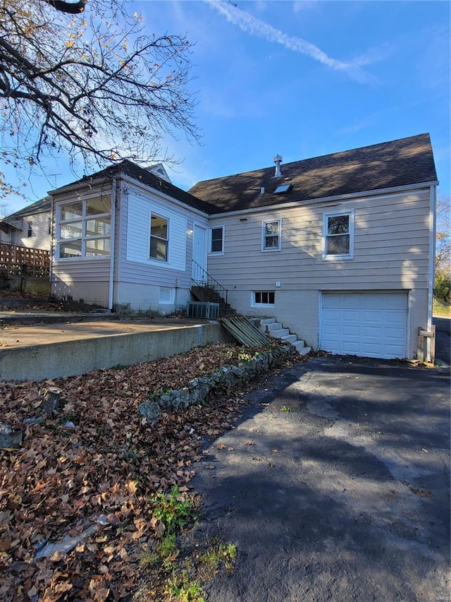 rear view of property with a garage