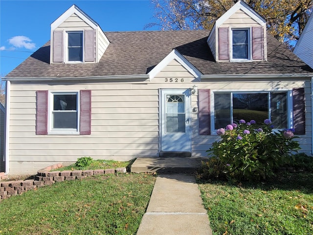 cape cod home featuring a front lawn