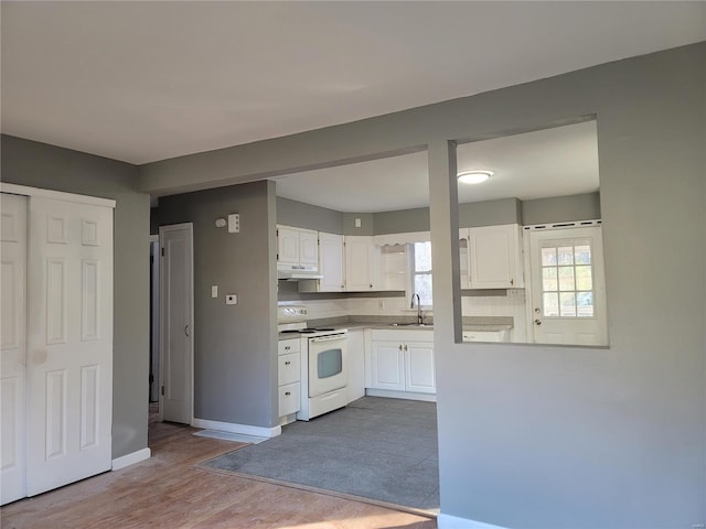 kitchen featuring decorative backsplash, sink, white cabinets, white electric range, and light hardwood / wood-style floors