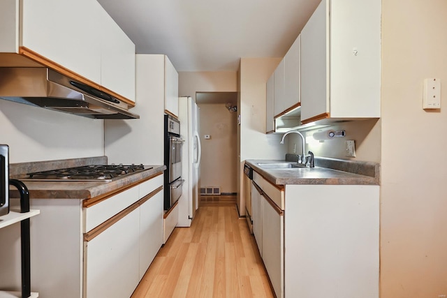 kitchen featuring stainless steel appliances, exhaust hood, sink, light hardwood / wood-style floors, and white cabinetry