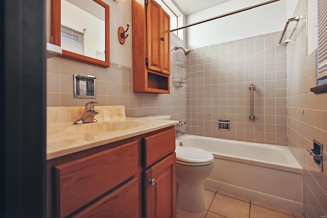 full bathroom featuring vanity, tile patterned floors, tiled shower / bath combo, toilet, and tile walls