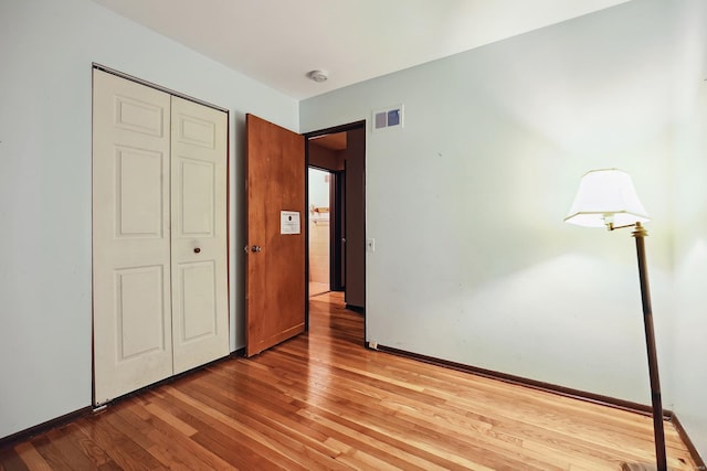 unfurnished bedroom with hardwood / wood-style floors and a closet