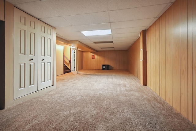 bonus room featuring light colored carpet and wooden walls