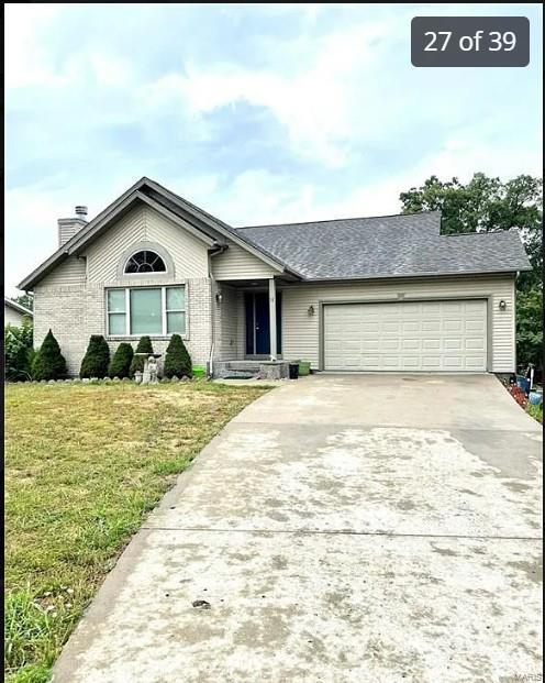 ranch-style home featuring a front lawn and a garage