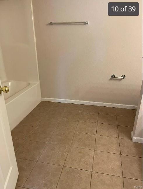 bathroom featuring tile patterned floors and a bath