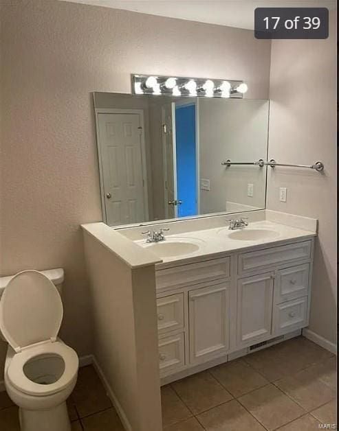 bathroom with tile patterned flooring, vanity, and toilet