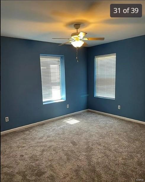 empty room featuring carpet flooring and ceiling fan