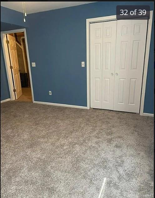 unfurnished bedroom featuring carpet flooring and a closet