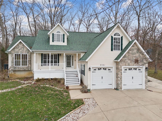 view of front of house featuring a porch, a garage, and a front lawn