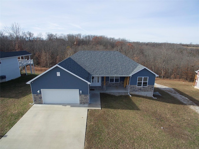 view of front of home featuring a porch, a garage, and a front yard