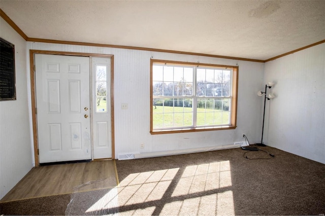 foyer featuring wood-type flooring, a textured ceiling, and crown molding