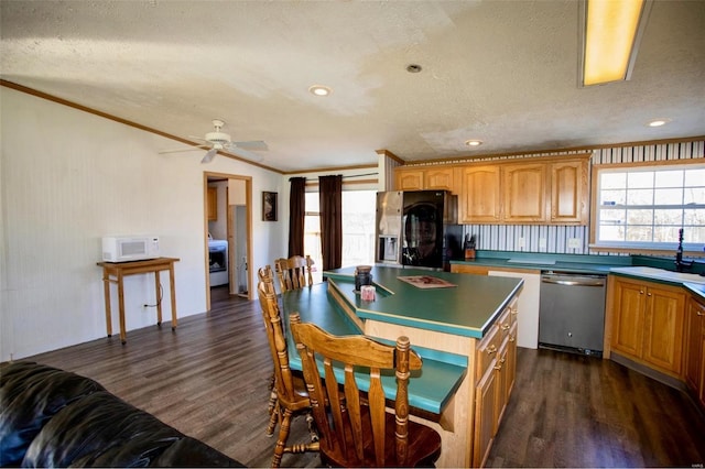 kitchen with dark hardwood / wood-style floors, crown molding, a textured ceiling, and appliances with stainless steel finishes