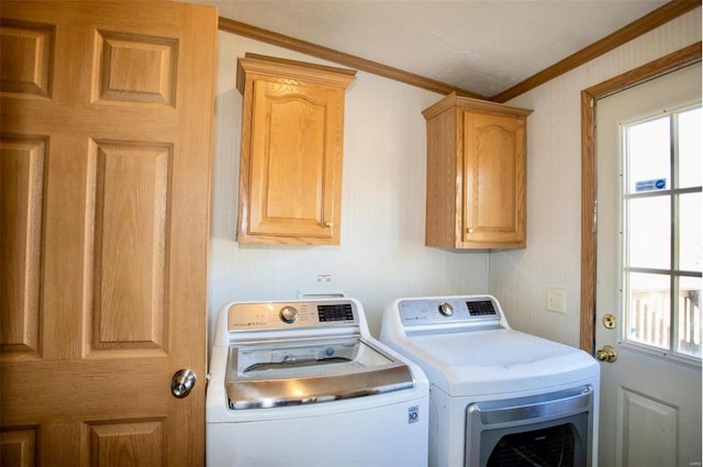 laundry area with cabinets, crown molding, and washing machine and clothes dryer