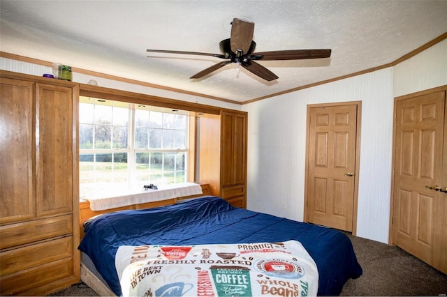 bedroom with carpet flooring, a textured ceiling, ceiling fan, and crown molding