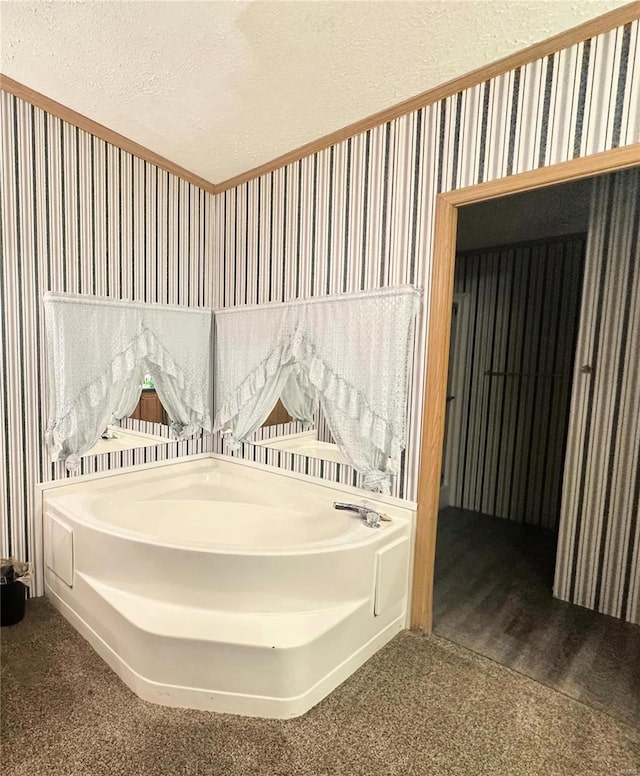 bathroom featuring a tub and a textured ceiling