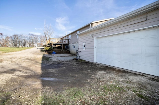 view of side of home featuring a garage and a wooden deck