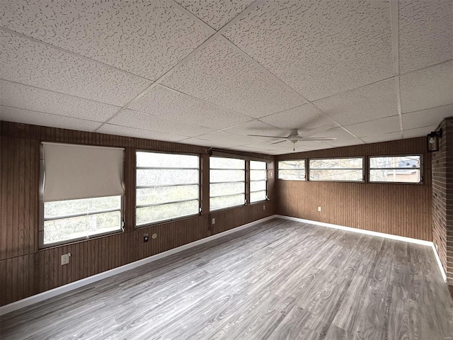 unfurnished sunroom with a paneled ceiling and ceiling fan