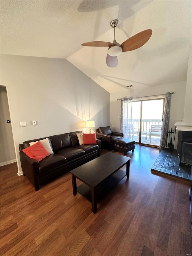 living room with a textured ceiling, dark hardwood / wood-style floors, ceiling fan, and lofted ceiling