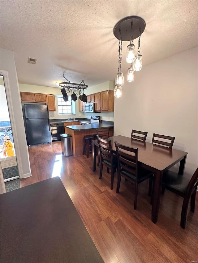 dining room with dark hardwood / wood-style flooring and a textured ceiling