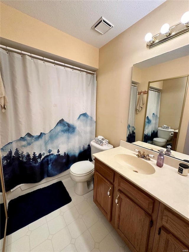 bathroom with vanity, a textured ceiling, and toilet