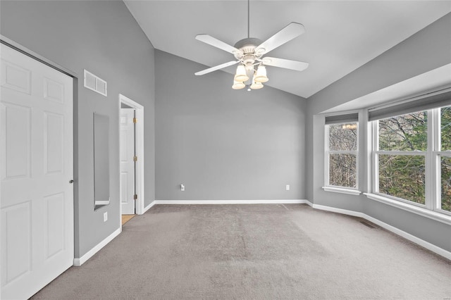 spare room featuring carpet flooring, ceiling fan, and lofted ceiling