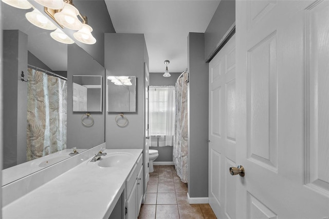 bathroom with toilet, vanity, and tile patterned floors