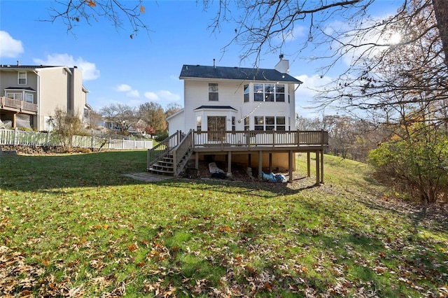 rear view of house with a wooden deck and a yard