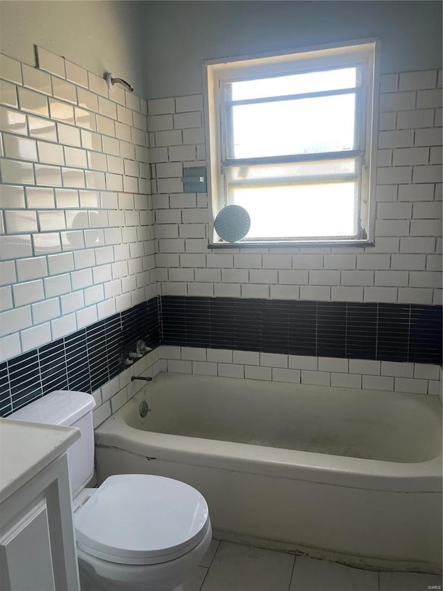 full bathroom with tile patterned floors, shower / bathtub combination, vanity, tile walls, and toilet