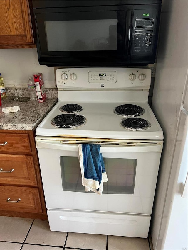 kitchen with light tile patterned floors and white electric stove