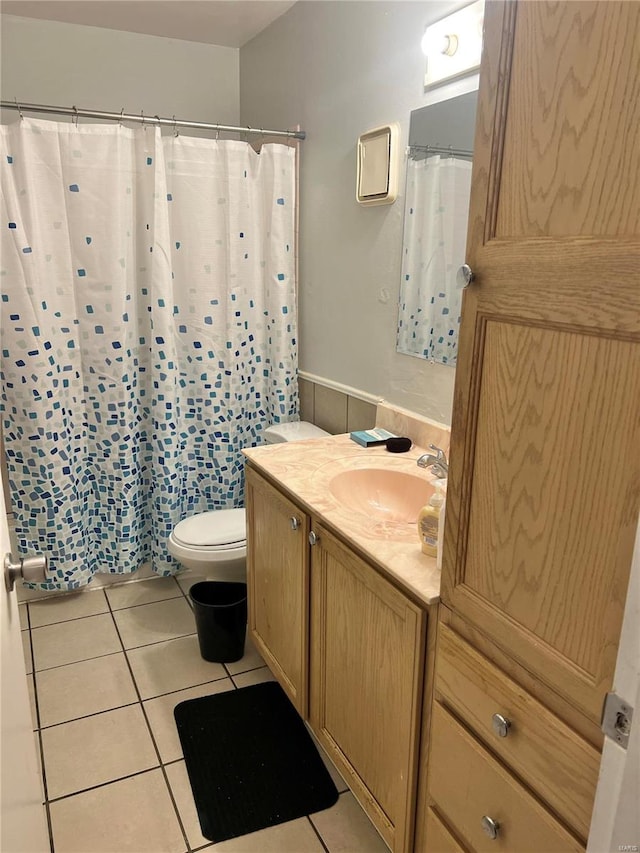 bathroom with tile patterned flooring, vanity, and toilet